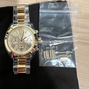 Michael Kors clear ceramic watch with gold accents.